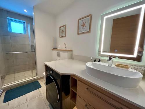 a white bathroom with a sink and a shower at Ocean grand gaube in Grand Gaube