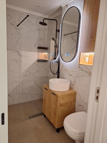 un bagno con lavandino e specchio di Mateo rezidence a Bistriţa