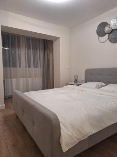 un grande letto bianco in una camera da letto con finestra di Mateo rezidence a Bistriţa