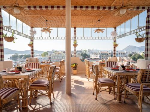 un restaurant avec tables et chaises avec vue dans l'établissement Bun and Bunks, à Udaipur