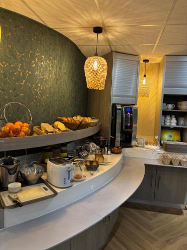 een keuken met een aanrecht met veel eten bij Hôtel Le Pavillon de Saint-Lô - anciennement Lunotel in Saint Lo