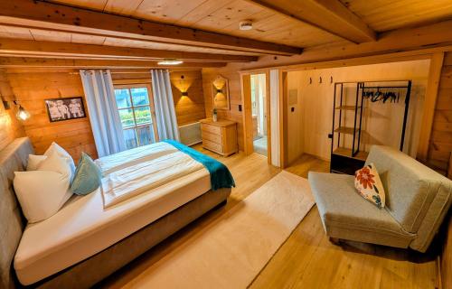 a bedroom with a bed and a chair in a room at Haus Dirol in Kirchberg in Tirol
