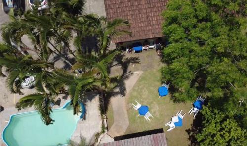 une vue aérienne d'un complexe avec piscine et palmiers dans l'établissement Pousada Perolas de Itanhaem, à Itanhaém