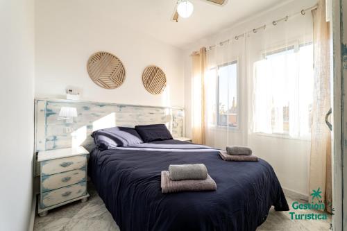 een slaapkamer met een bed met twee handdoeken erop bij Zuri's Loft Islantilla Golf in Isla Cristina