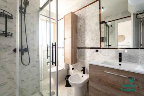 een badkamer met een wastafel, een toilet en een douche bij Zuri's Loft Islantilla Golf in Isla Cristina