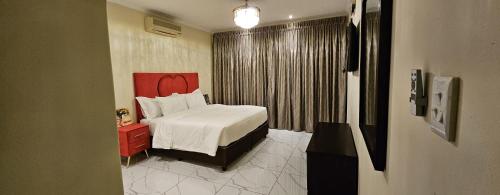 een slaapkamer met een bed en een rood hoofdeinde bij Pink Rock Villa in Durban