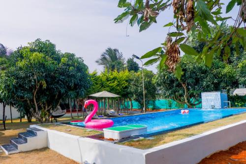 a swimming pool with a pink flamingo in the middle at Eco Serenity Pet-friendly Charming 2-BHK Villa With Lush Garden, Gazebo, Private Pool & Open Dining Close to Nandi Hills in Oddarahalli