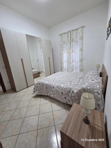 een slaapkamer met een bed en een tafel met een lamp bij B&B Domus Morfeo 2 in Casagiove