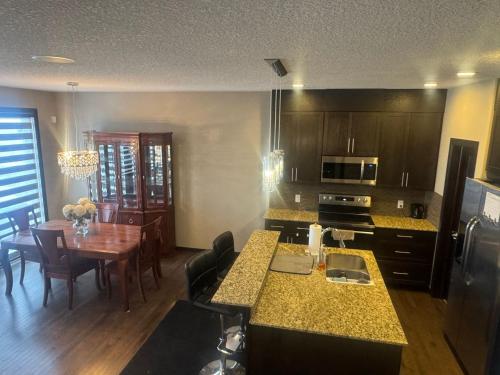 a kitchen and dining room with a table and a kitchen with at Panorama Haven in Calgary