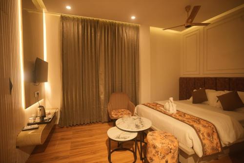 a hotel room with a bed and a table at Meghnad By Padmaraag in Nalbāri