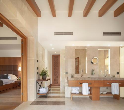 a bathroom with a sink and a large mirror at Castell Son Claret - The Leading Hotels of the World in Capdellá