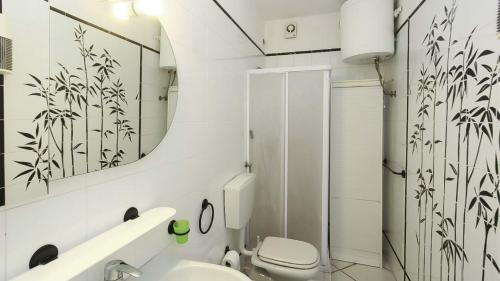 een badkamer met een toilet, een wastafel en een spiegel bij Il Porto 13 - Goelba in Porto Azzurro