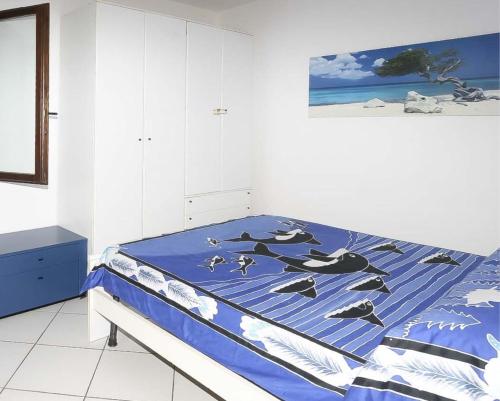 een slaapkamer met een bed met een blauw dekbed bij Il Porto 13 - Goelba in Porto Azzurro