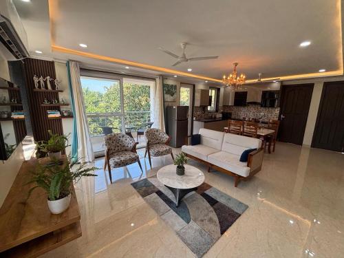 ein Wohnzimmer mit Sofa und Tisch in der Unterkunft Monstera-Kudrat's Nilaya in Canacona