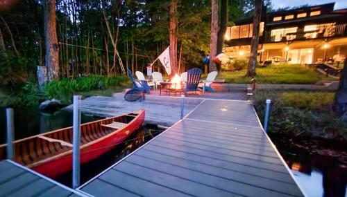 a wooden dock with a boat on the water at Lakefront Hot Tub Canoes Game Room Wood FP in Gouldsboro