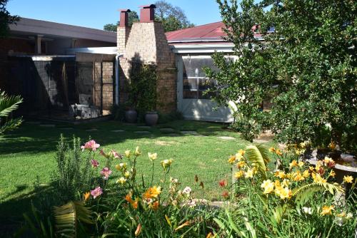 um jardim com flores em frente a uma casa em Siesta B&B em Vryheid