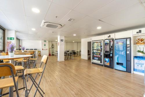 una caffetteria con tavoli e sedie e un distributore automatico di Hostal Sans a Barcellona