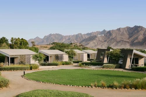 a row of houses with mountains in the background at JA Hatta Fort Hotel in Hatta