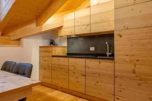 una cucina con mobili in legno e un piano di lavoro di Appartamenti Dolomites Elements a Caprile