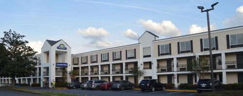 a large white building with cars parked in a parking lot at Days Inn by Wyndham Marietta-Atlanta-Delk Road in Marietta