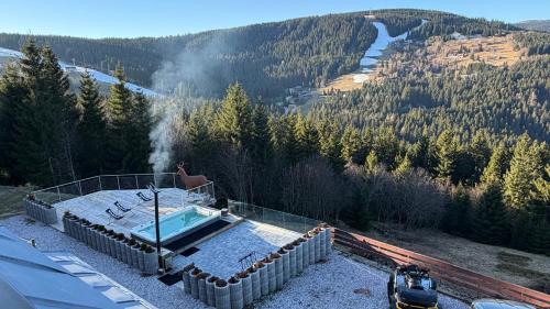 uma banheira de hidromassagem no topo de uma casa com vista para a montanha em Bílá Labuť Pec em Pec pod Sněžkou