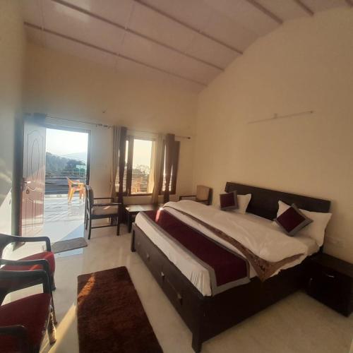 a bedroom with a large bed and a balcony at Apple Hilltop Homestay in Chaubattia