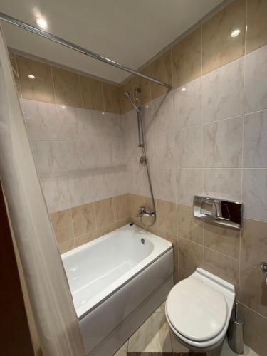 ein Badezimmer mit Badewanne, Toilette und Waschbecken in der Unterkunft PM Services Royal Plaza Apartments in Borowez