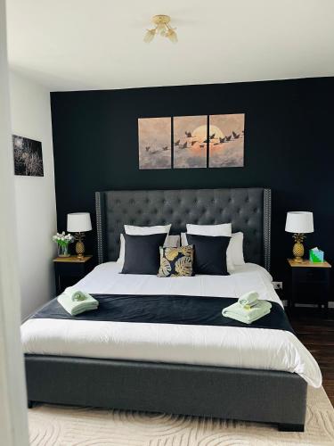 a bedroom with a large bed with a black wall at Ancien Relais de Poste The Old Post Office in Saint-Martial-dʼAlbarède