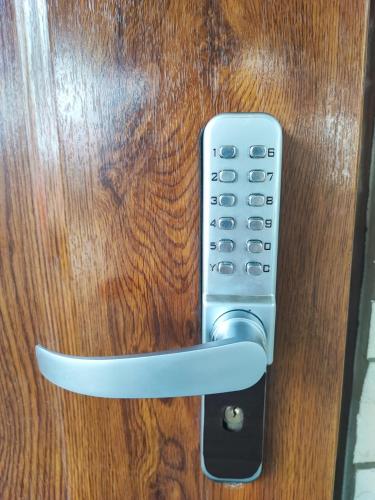 a remote control is attached to a wooden door at Apartament in Psary Małe