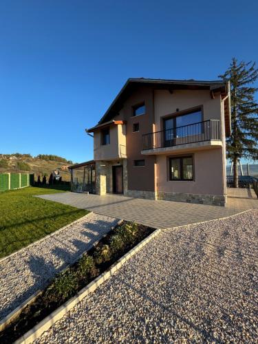 ein Haus mit einem Gehweg davor in der Unterkunft Къща за гости Пегас in Welingrad