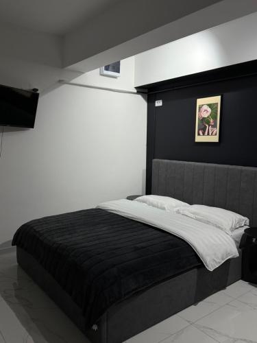 una camera con letto e testiera nera di ApartStudio28 Craiova a Craiova