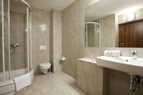a bathroom with a sink and a shower and a toilet at B&B HOTEL Tychy in Tychy