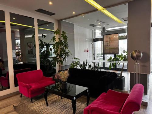 a living room with red chairs and a black couch at B&B HOTEL Tychy in Tychy