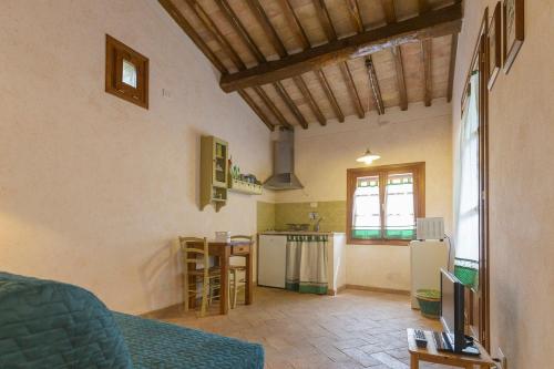 a living room with a couch and a kitchen at Casetta di Pietra by ElbaSummer in Marciana
