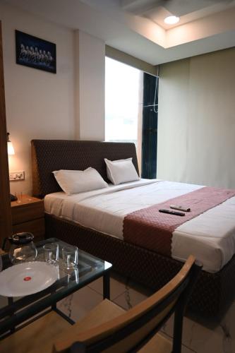 a hotel room with a bed and a table and a table and a tableablish at HOTEL RV PARK Inn MOGAPPAIR in Chennai