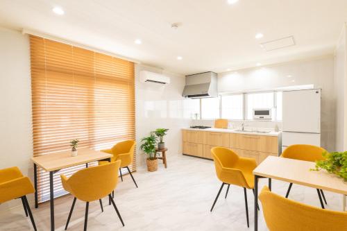 an open kitchen and dining room with yellow chairs and tables at 栞-shiori-FUNAKURA in Ishigaki Island