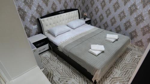 een klein bed met twee witte kussens erop bij RegistanStay - Private House 2 Min Walk to Registan in Samarkand