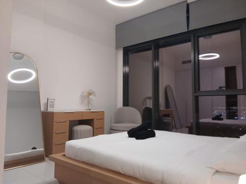 a bedroom with a bed and a desk and a mirror at Appartement Dubai in Dubai