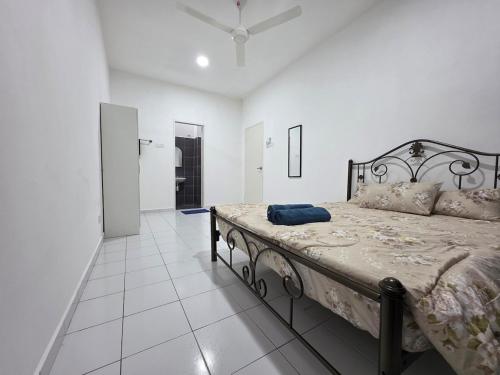 a bedroom with a bed in a white room at Homestay Zea in Gambang
