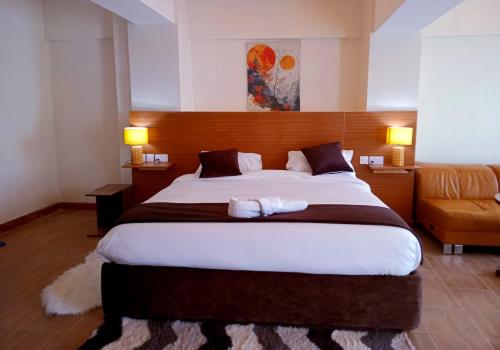 une chambre avec un grand lit et un canapé dans l'établissement Montage Luxury Hotel, à Kitengela 