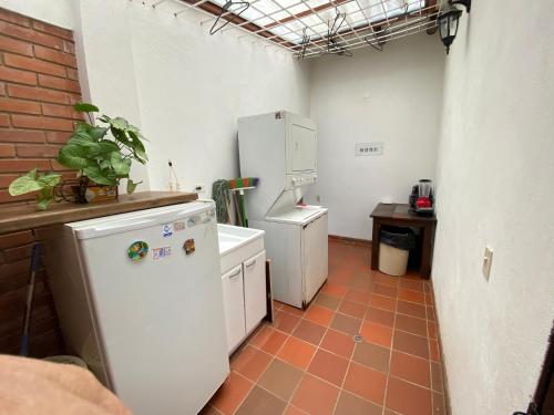 una cucina con elettrodomestici bianchi e pavimento piastrellato di VillaMoreno - Casa Campestre a Ramiriquí