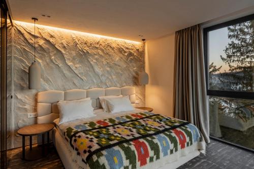 a bedroom with a bed and a large window at Mountain air Legit in Palyanytsya