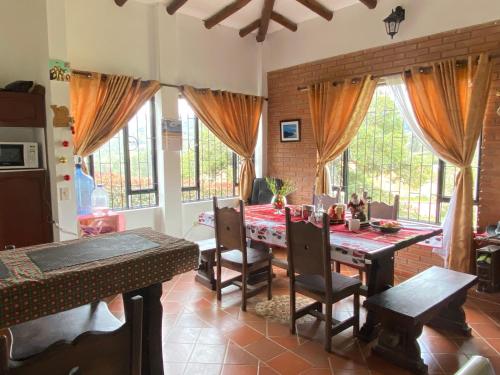 una sala da pranzo con un tavolo e alcune finestre di VillaMoreno - Casa Campestre a Ramiriquí