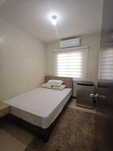 Un dormitorio pequeño con una cama y una ventana. en Teves Suite Lipa City, en Lipá
