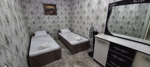 een badkamer met 2 bedden en een spiegel bij RegistanStay - Private House 2 Min Walk to Registan in Samarkand