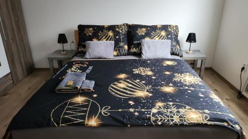a bed with a black comforter with lights on it at Olšany Home - útulný privátní domek se zahradou a parkováním u Olomouce - private house with garden and parking near Olomouc 