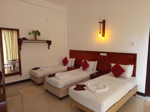 ein Hotelzimmer mit zwei Betten und einem Spiegel in der Unterkunft Celestia by Sea Cloud in Talpe