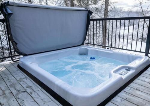 Spa and Sauna - Riverside - Brand New- SKOV Chalets في Saint Come: يوجد حوض جاكوزي على السطح.