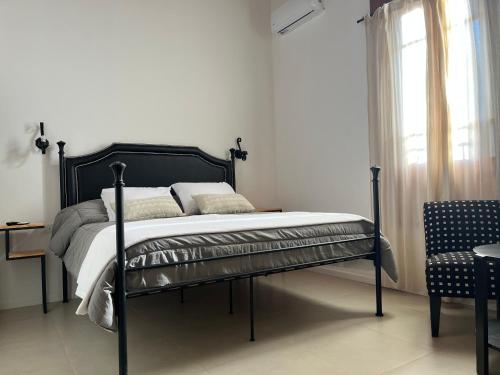 een slaapkamer met een bed, een stoel en een raam bij Farrell Suite Casco Historico in San Antonio de Areco