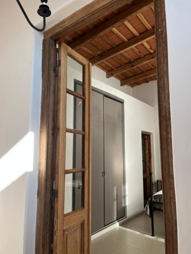 een open houten deur in een kamer met een spiegel bij Farrell Suite Casco Historico in San Antonio de Areco
